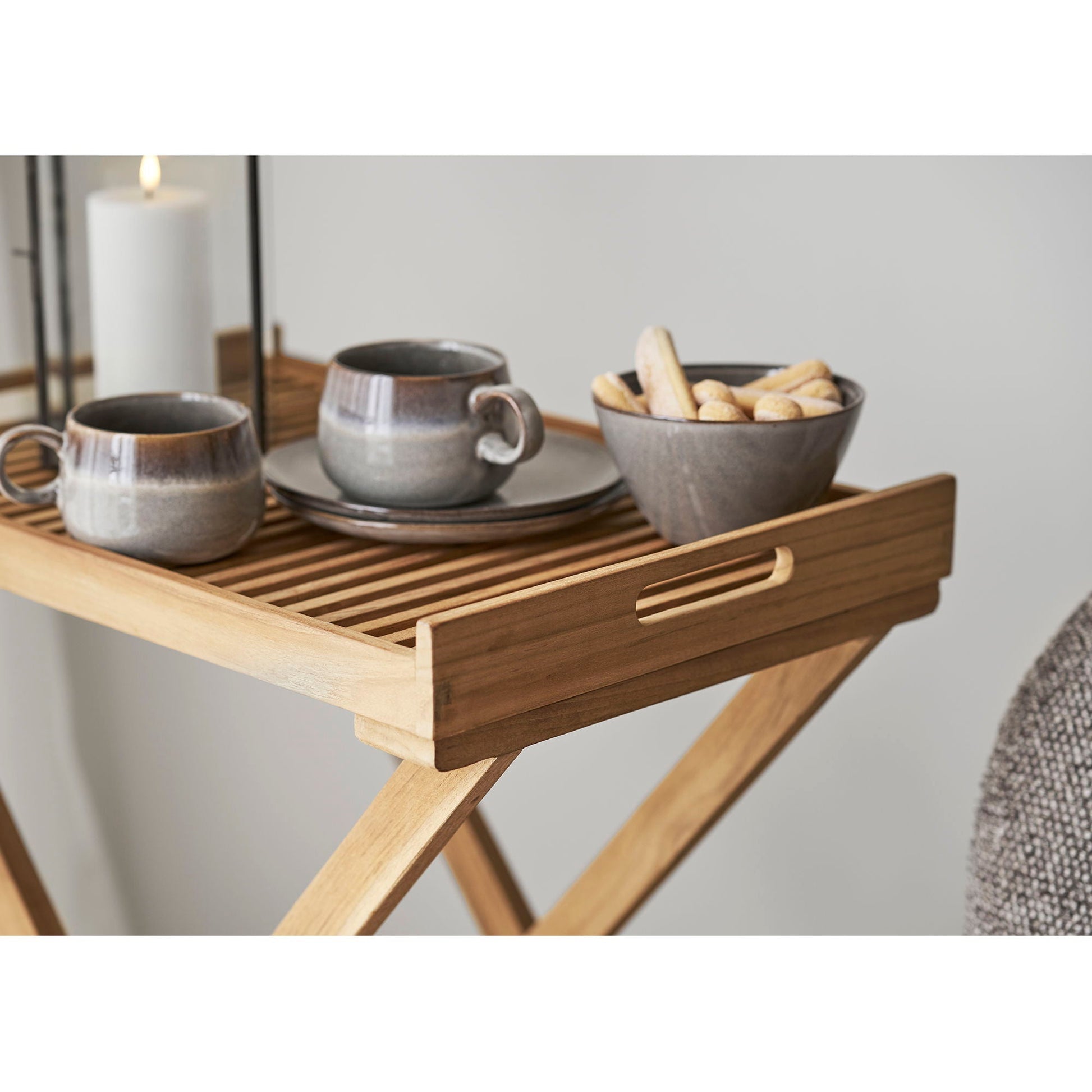 Zijdelingse blik op slatted dienblad van Ronda dienbladtafel in House Nordic teakhout, los gepositioneerd naast X-poot
