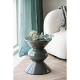 House Nordic Rosolina bijzettafel gestyled met witte bloesem en eucalyptus naast een creme bouclé fauteuil en groen gordijn