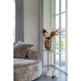 Slank duo van House Nordic Salo tafels met marmer en messing, gestyled met bruin glasvaas en rooswit takboeket bij sofa