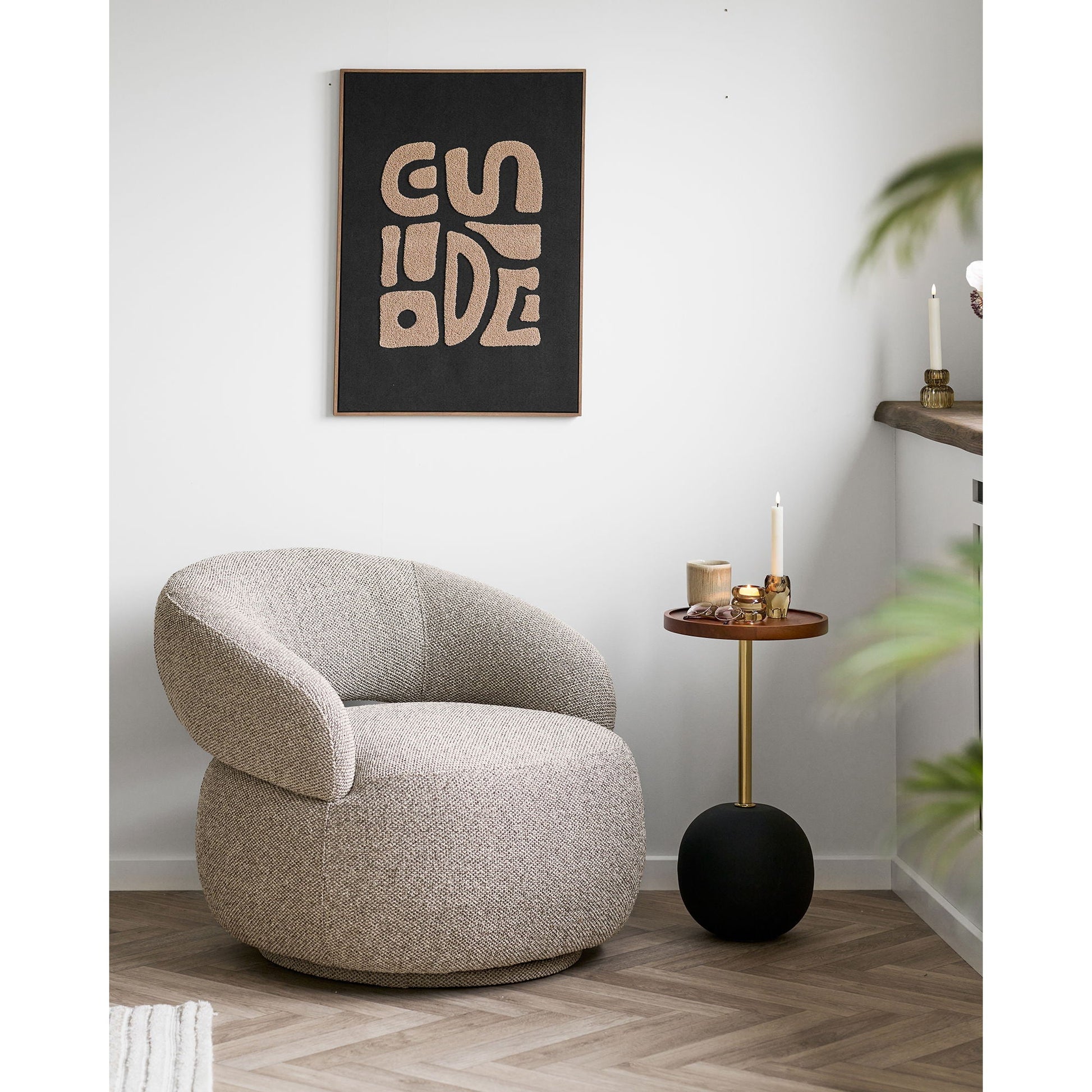 House Nordic Sirone bijzettafel in stijlvolle zithoek bij gebogen bouclé fauteuil, gestyled met kaars, vaas en boek