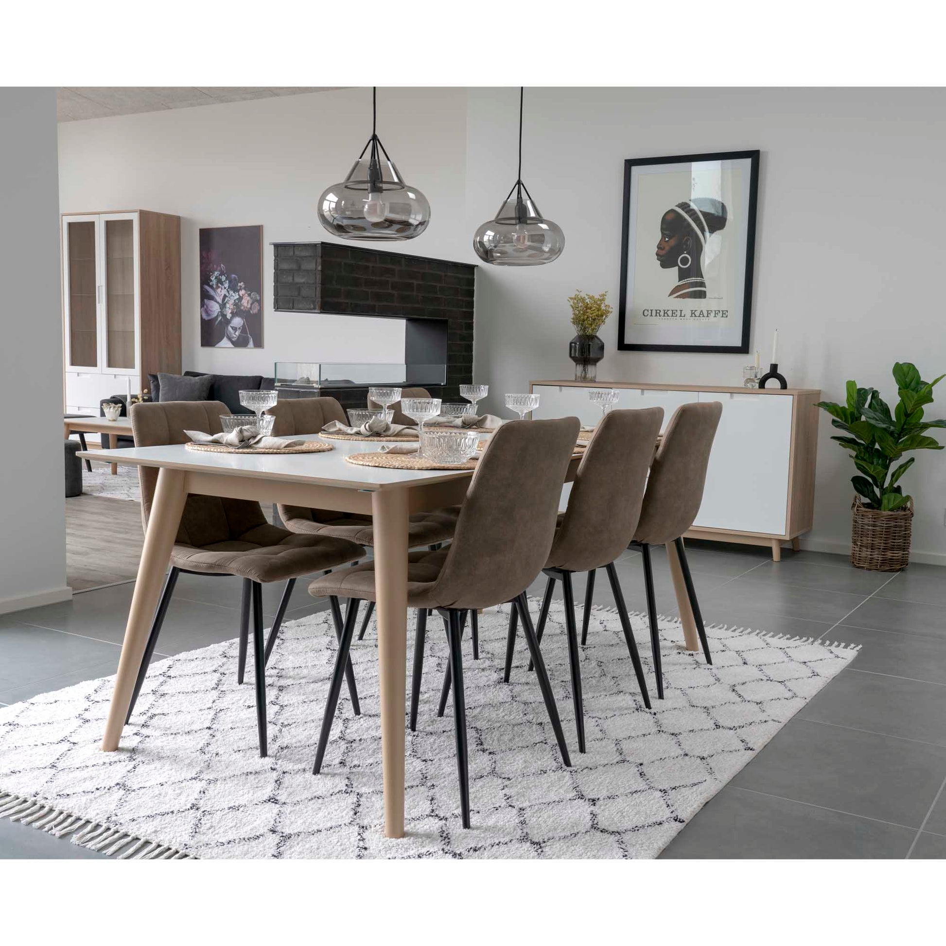 Moderne eetkamer met houten tafel, zes bruine stoelen, geometrisch tapijt en kunst 'Cirkle Kaffe' aan de muur.
