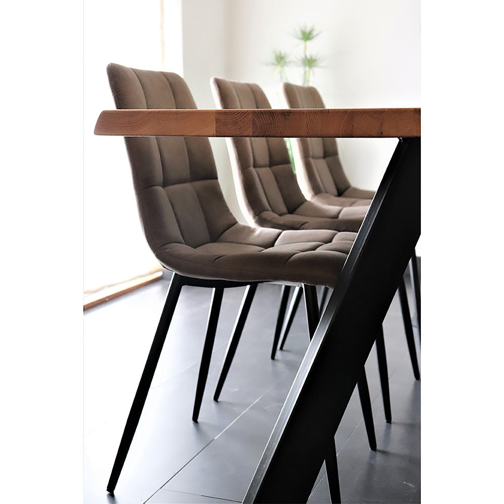 Bruine gestoffeerde eetkamerstoelen rondom een houten tafel met metalen poten, moderne inrichting.