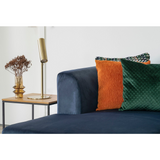 Scandinavische woonkamer met Vita bijzettafel van House Nordic naast smaragdgroene bank en open wandrek.
