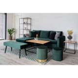 Sfeervol beeld van Vita bijzettafel van House Nordic naast twee groene velvet poefs op een geometrisch tapijt.