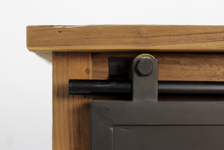 Houten schuifdeurrail met metalen glijder en bout, detail van rustiek interieurontwerp.