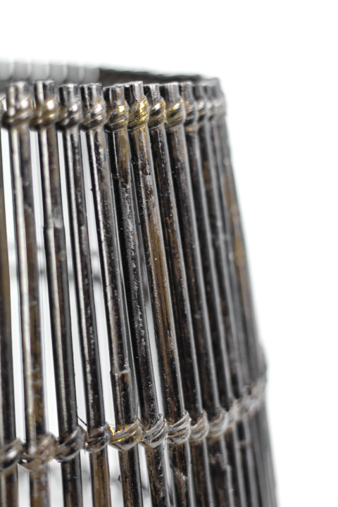 Close-up van een cilindrische metalen draadstructuur met verticale staven en een roestige uitstraling.