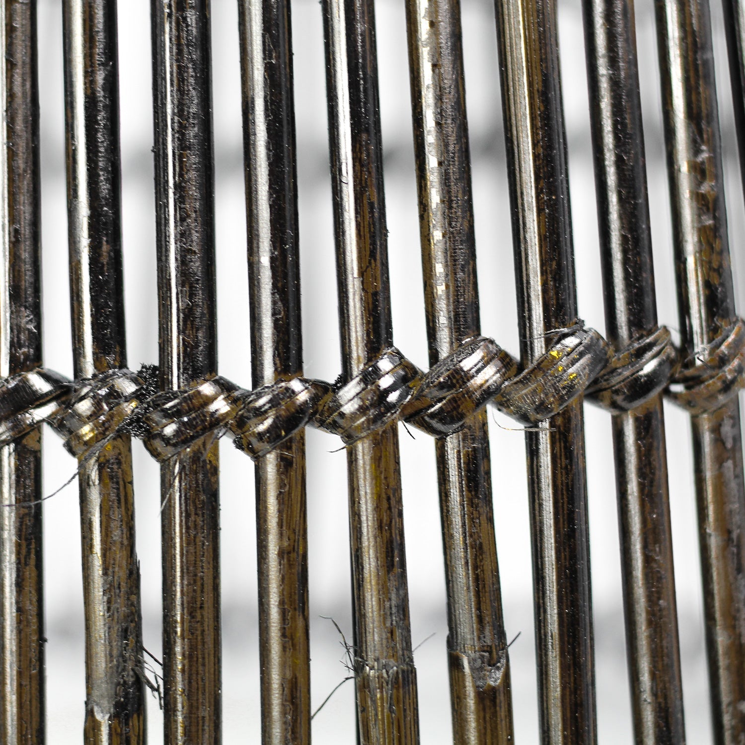 Close-up van metalen pennen geweven met dunne draden, met een licht briljante en industriële uitstraling.