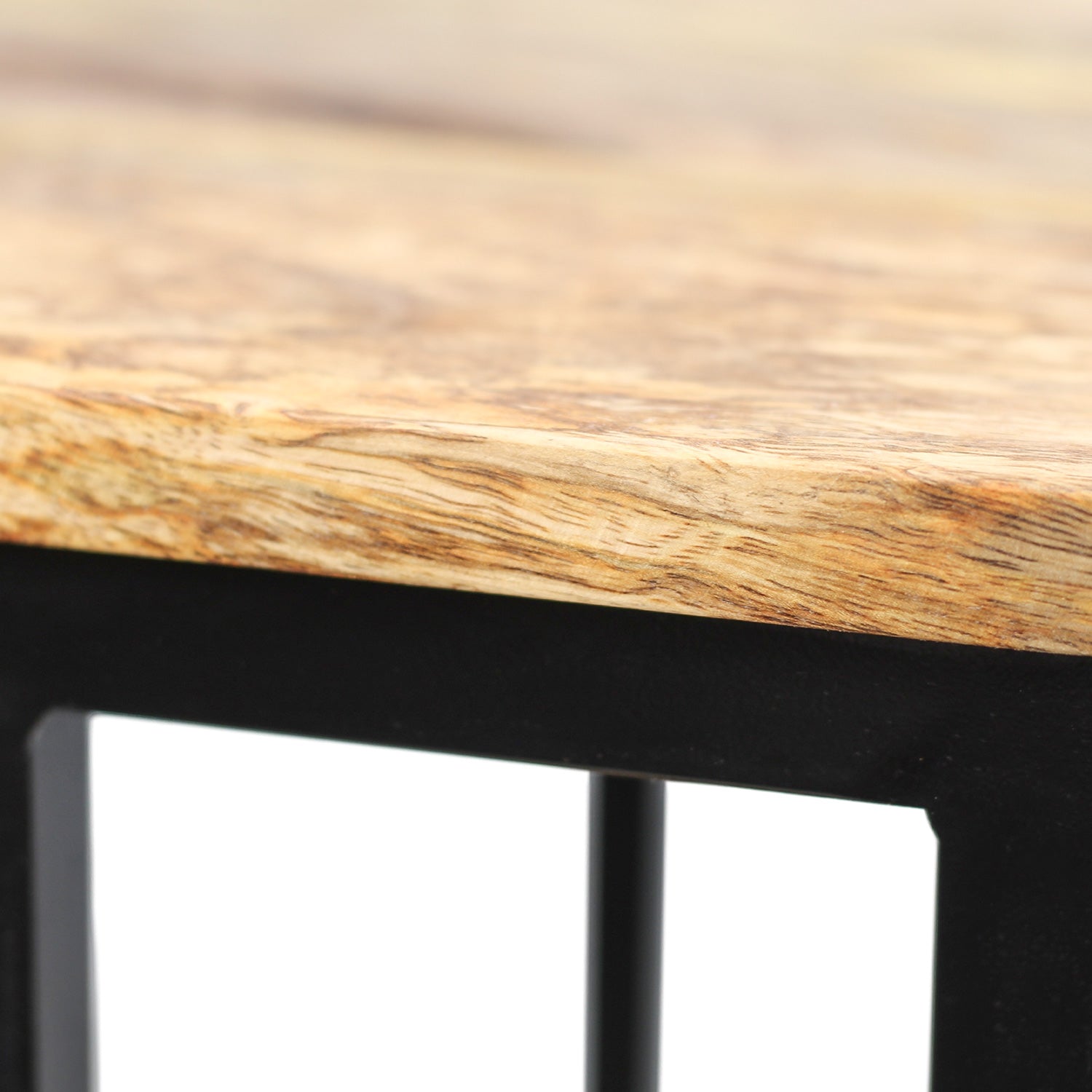 Hoek van een houten tafelblad met stijlvolle zwarte metalen poten, met natuurlijke houtnerven zichtbaar.
