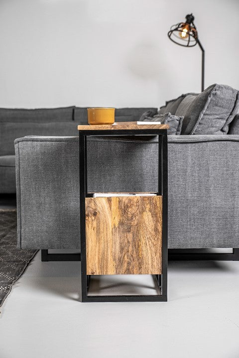 Moderne bijzettafel met houten blad en zwart metalen frame naast donkergrijze bank, gele mok bovenop.