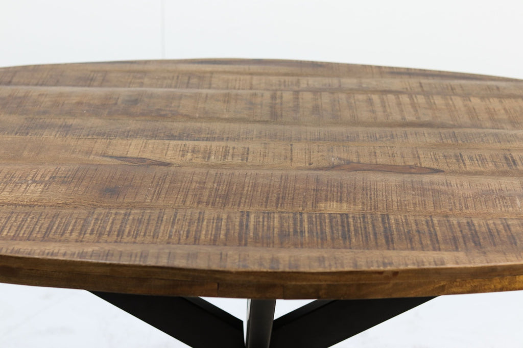 Rond houten tafelblad met natuurlijke houtnerven en warme bruine tinten. Zwart metalen onderstel zichtbaar.