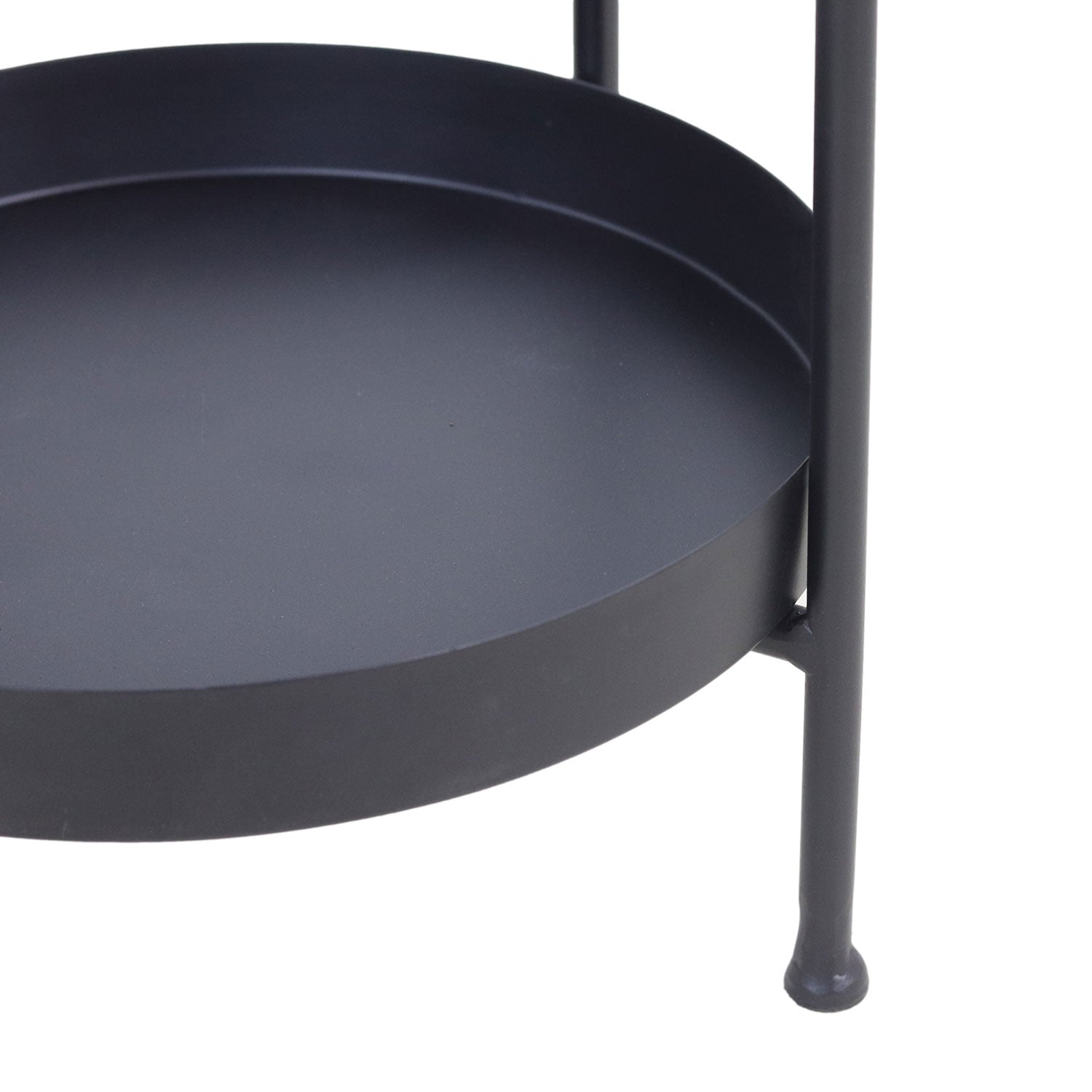 Detail van een matzwarte metalen tafel met een ronde plank, minimalistisch en strak design.