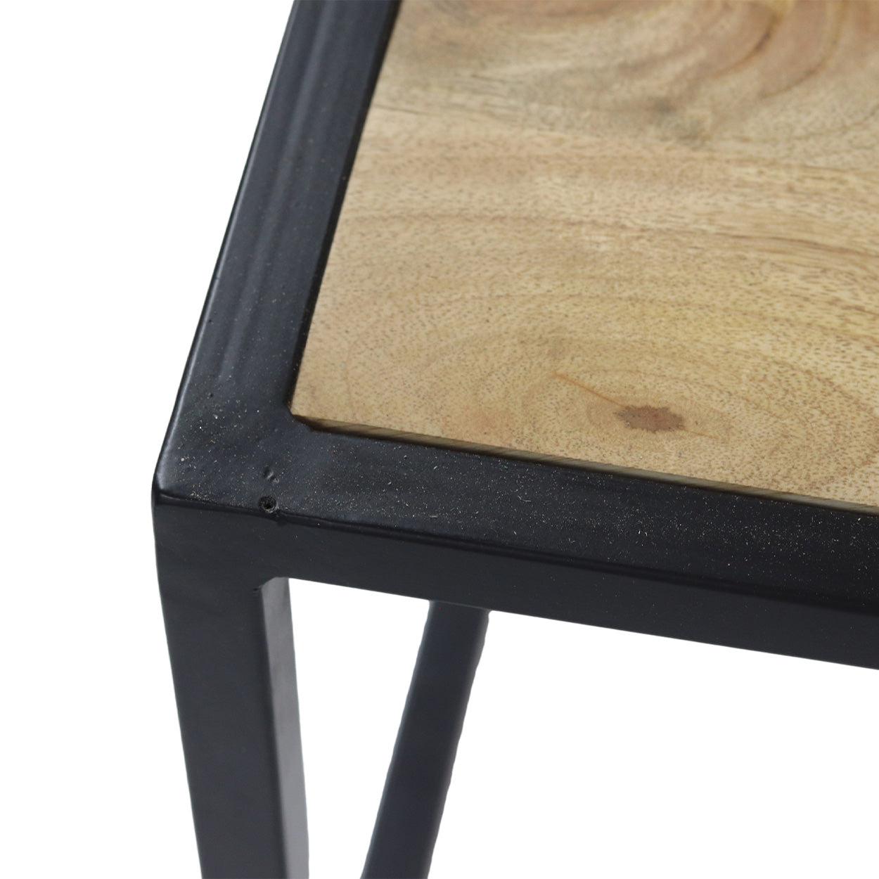 Houten tafelblad met natuurlijke nerf, omlijst door een strak zwart metalen frame in close-up.
