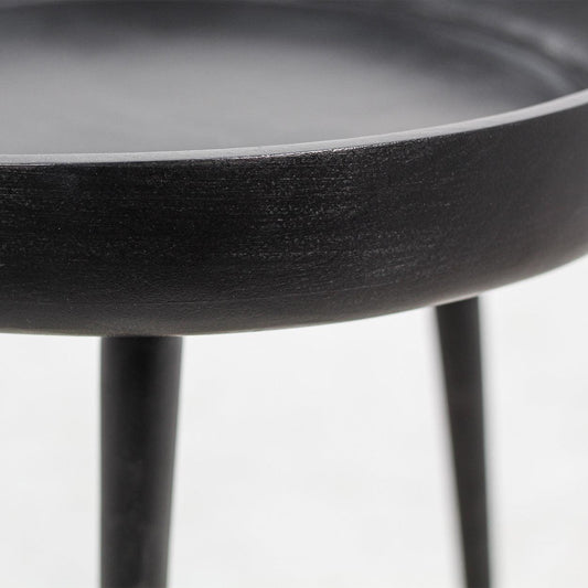 Zwart bijzettafeltje met ronde schotelvormige bovenkant en slanke poten, minimalistisch ontwerp.
