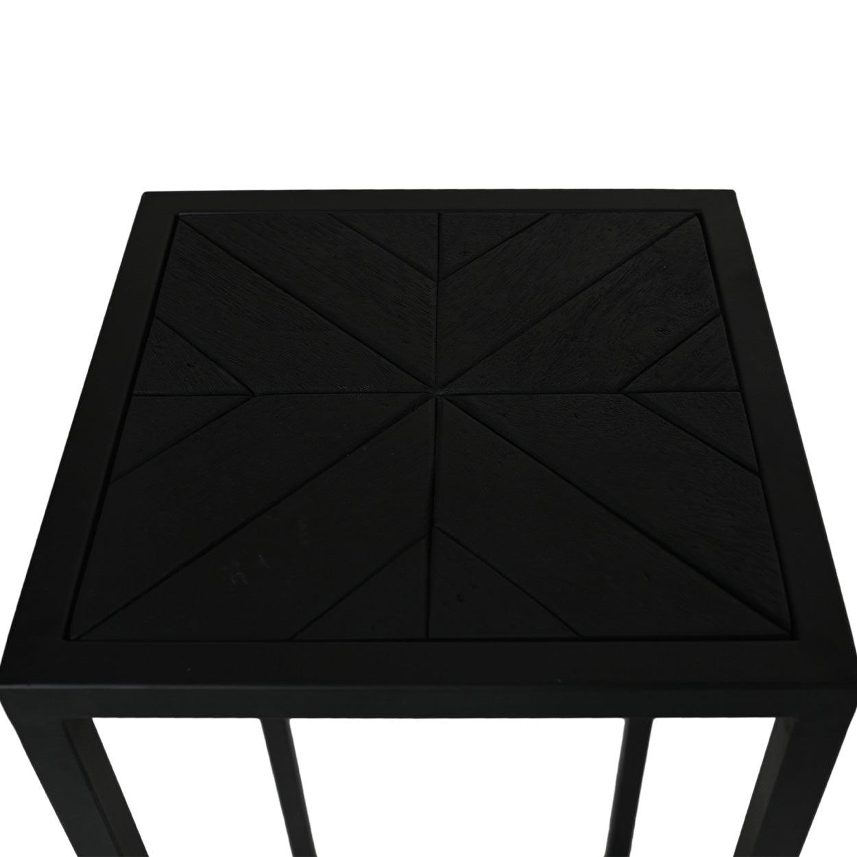 Zwart houten bijzettafeltje met geometrisch patroon op het tafelblad, minimalistisch design en strakke lijnen.
