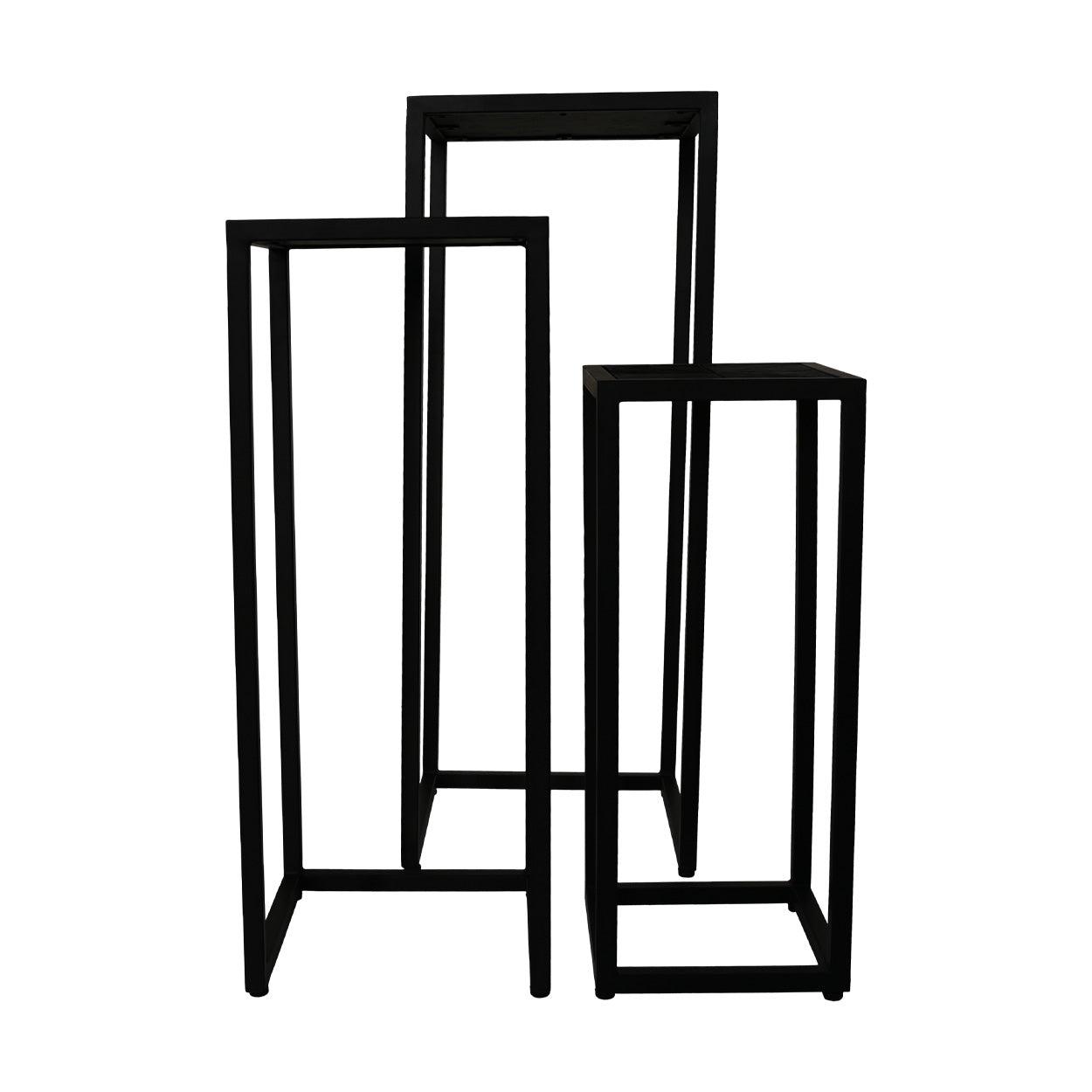 Drie zwarte metalen sokkels van verschillende hoogtes, geschikt voor decoratieve presentatie of tentoonstellingen.