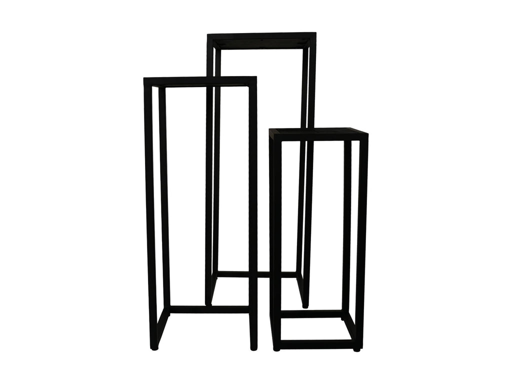 Drie zwarte metalen plantenzuilen van verschillende hoogtes tegen een witte achtergrond. Minimalistisch ontwerp.
