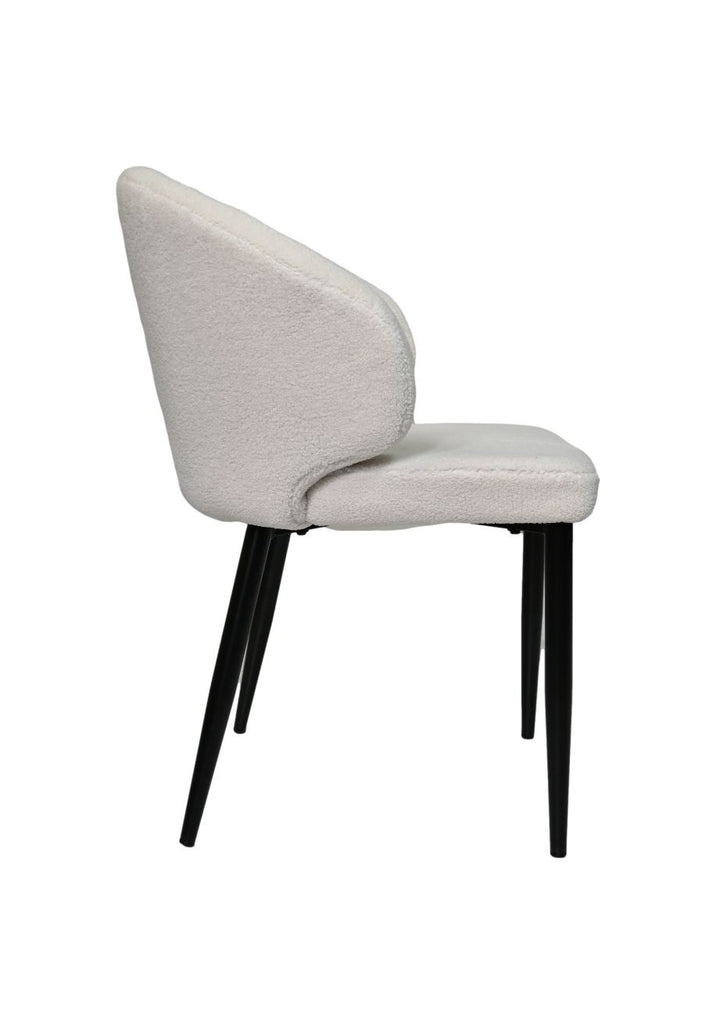Elegante witte stoel met zachte bekleding en slanke, zwarte poten, zijaanzicht voor een moderne inrichting.