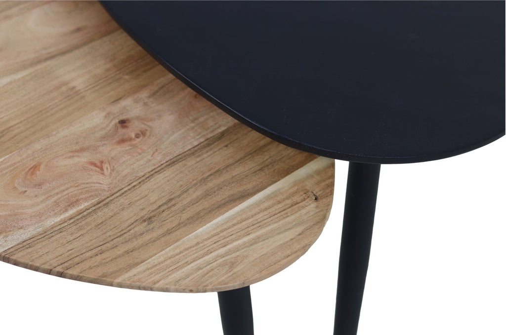 Twee overlappende tafels met zwart blad en houten blad, elk met slanke zwarte poten, modern minimalistisch design.