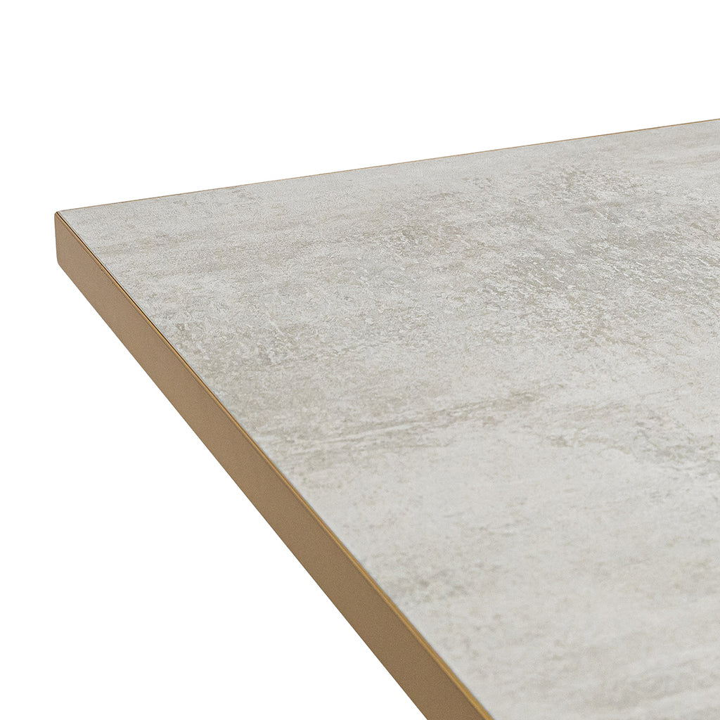 Close-up van een moderne, beige, matte tafelblad met textuur, afgewerkt met een dunne gouden rand.