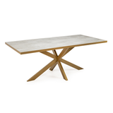 Rechthoekige tafel met betongrijs blad en goudkleurige metalen kruispoot, minimalistisch en modern design.