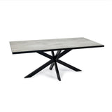 Rechthoekige tafel met grijs stenen tafelblad en zwart metalen gekruiste poten, modern design.