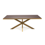 Rechthoekige houten tafel met gouden randen en V-vormige goudkleurige poten tegen witte achtergrond.